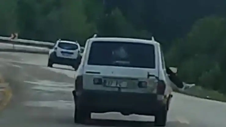 Trafikteki tehlikeli yolculuk kameraya yansıdı: Ayaklarını camdan sarkıttı